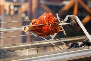 Mexican style marinated pork meat on a spindle Al Pastor Tacos. The meat is cooked and then lightly fried to be enjoyed on a taco with salsa, onion and cilantro. photo