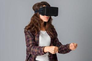 Linda mujer joven en casco de realidad virtual foto