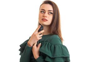 Portrait of beautiful young girl in green dress with microphone in her hands photo