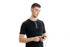 young charming guy closed his eyes and listens to music with headphones photo