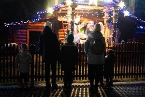 Family against scene where the Virgin Mary gave birth to Jesus and he lies in the cradle surrounded by people who have come to celebrate the Nativity of Christ. photo