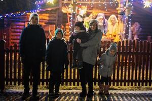 Family against scene where the Virgin Mary gave birth to Jesus and he lies in the cradle surrounded by people who have come to celebrate the Nativity of Christ. photo