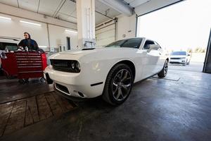 Mechanic in service repair station working with muscle car. photo