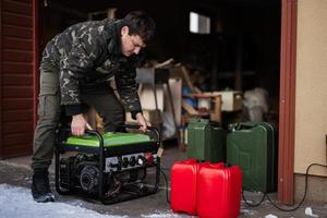 Man wear in military jacket with gasoline portable mobile backup standby generator. photo