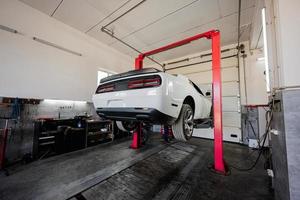 Muscle car at service repair station in lift. photo