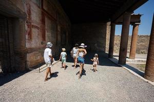turista familiar caminando en la ciudad antigua de pompeya, italia. foto