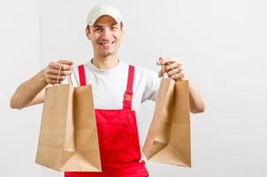 Diverse of paper containers for takeaway food. Delivery man is carrying photo