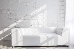 Bright, minimalist living room interior with white sofa standing near the window and black stool photo