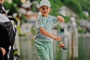 niño juega con una muñeca de juguete de madera en hallstatt, austria. foto