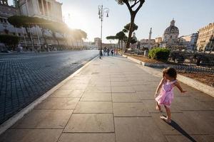 Baby girl against Santa Maria di Loreto church in Rome, Italy. photo