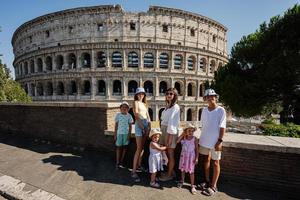 Mother with five kids pose against Colosseum in the old city center of Rome, Italy. photo