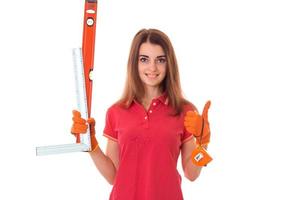 young happy brunette woman builder in uniform with tools in her hands make reovations isolated on white background photo