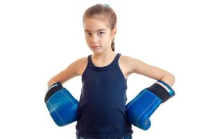 the little girl is standing in a large adult boxing gloves and looking at camera photo