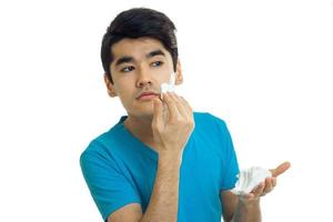 Portrait of a handsome guy with black hair who took a glance to the side and putting face foam photo