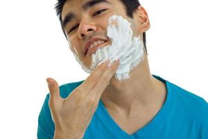 a close-up portrait of the beautiful smiling guy with foam on his face photo