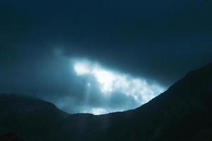 Foto de dramáticos rayos de luz empujando hacia arriba a través de las nubes