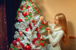 Red hair freckles young woman decorated a christmas tree photo