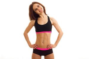 beautiful young girl in top and shorts with elastic tummy put hands on hips and smiling photo