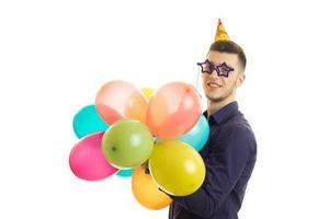 joven gracioso con gafas en forma de estrellas tiene bolas de cumpleaños foto