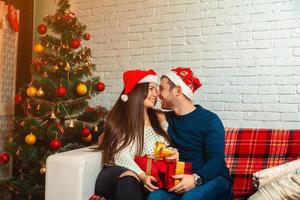 young family in love look at each other's eyes and laughing on Christmas Eve photo