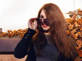 Girl with red hair and sunglasses smiling photo