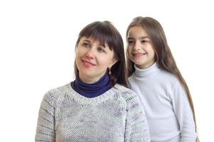 mamá e hija sonriendo y mirando hacia un lado foto