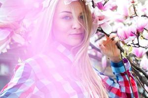 Young pretty girl in pink flowers enjoying life photo