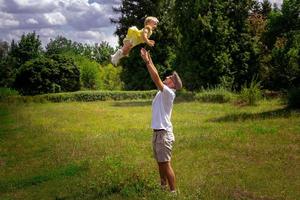 elegante padre joven divirtiéndose con su pequeña hija foto