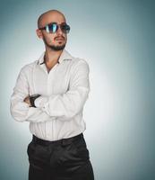 Nice man with berad and sunglasses looking away in studio photo