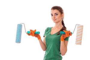 young beauty brunette woman builder in uniform with paint roller in hands make reovations isolated on white background photo