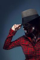 Profile portrait of woman with scary face art and hat  in studio photo