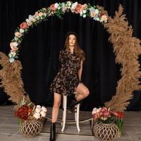 Beautiful woman posing at circle of deadwood in dress with flower print photo