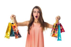 young girl with  huge surprise holds the sides bright bags  giveaways is isolated on  white background photo