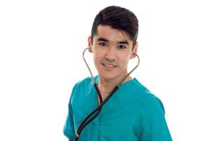 cheerful elegant doctor in blue uniform with stethoscope posing and smiling on camera isolated on white background photo