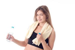 Sports girl holding a bottle of water and  towel on the shoulders  isolated  white background photo