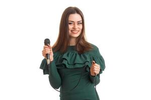 chica alegre con micrófono en vestido verde foto