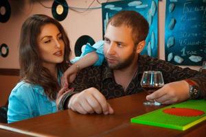 drunk guy flirting with a beautiful brunette in a bar photo