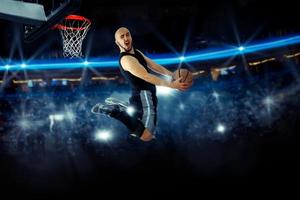 Horizontal photo of basketball player in the game makes reverse slam dunk