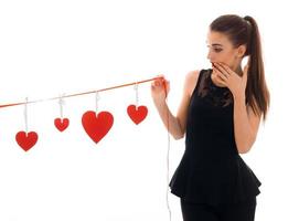 Surprised young brunette woman with red heart in hands posing isolated on white background. Saint Valentine's day concept. Love concept. photo
