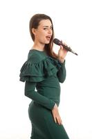 Lovely brunette lady in green dress with microphone photo