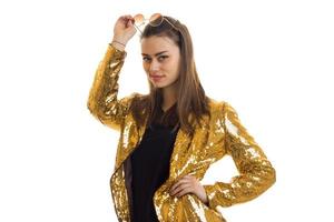 beautiful brunette in a gold jacket smiles at the camera photo