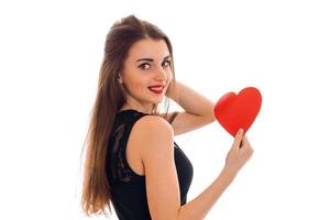 young cheerful brunette lady with red heart in hands smiling on camera isolated on white background. Valentines Day concept. photo