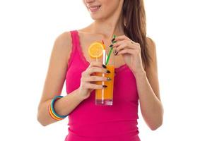 lovely young girl in pink shirt drink orange cocktail and smiling isolated on white background photo