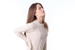 the girl stands sideways and chvvstvuet back pain is isolated on a white background photo