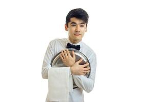 young beautiful funny waiter with a butterfly on his neck pressed to imagine empty tray for Cookware photo