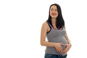 Young cheerful pregnant mother smiling and looking away isolated on white background in studio photo