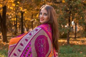 sweet girl keeps the big pink scarf on the shoulders and smiles photo