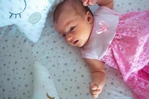 Adorable newborn girl in pink dress photo