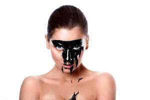 Portrait of sensual woman with black paint on face photo