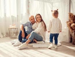 Young family at home in ltgh bedroom with thier daughter photo